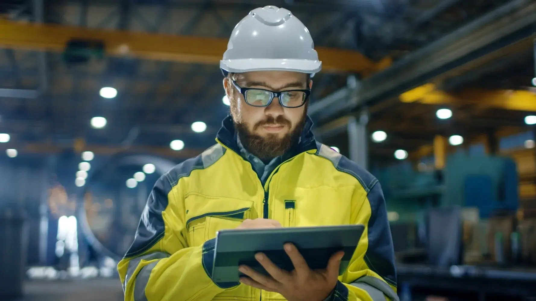Person wearing safety gear and looking at tablet